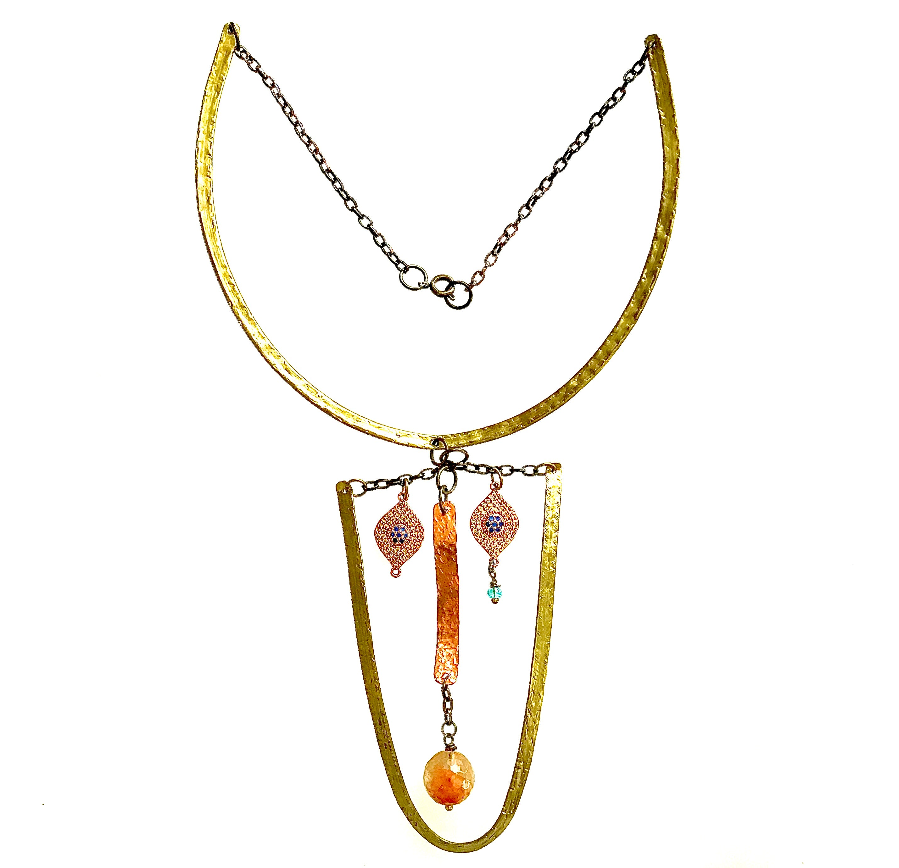 Brass collar necklace with elongated face made of hammered brass, eyes made of evil eye charms, nose made of hammered, curved copper suspended in middle from a length of chain. Copper has a round agate bead hanging to make the mouth.
