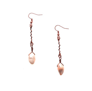 Shows copper and pearl drop earrings featuring squiggly copper wire with a dangling, teardrop-shape peach-colored pearl.